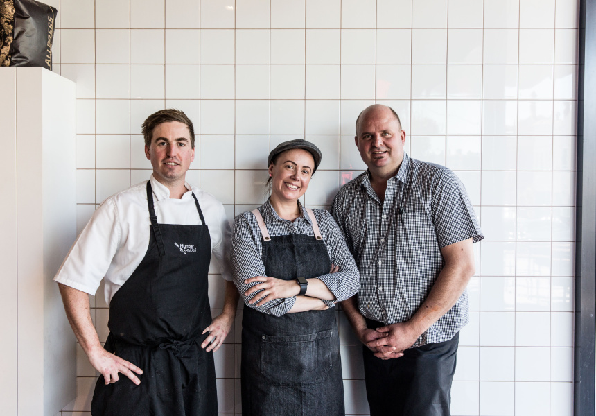 Three chefs standing smiling at camera